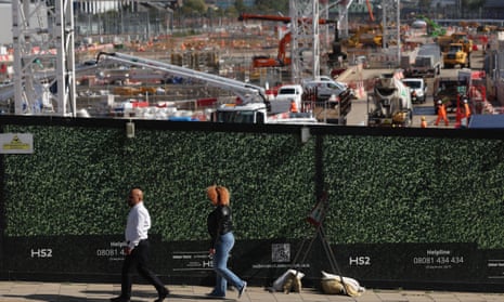 A couple walk past a hoarding at the HS2 construction site at Old Oak Common, London.