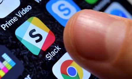 A finger hovering above the Slack icon on a phone screen.
