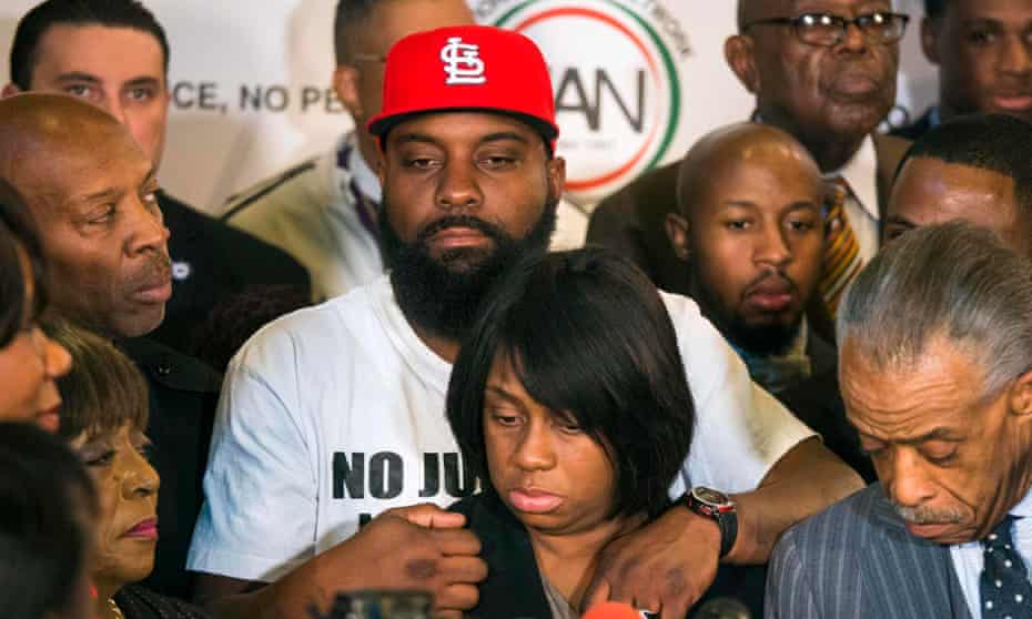Michael Brown Sr. holds his wife Cal Brown during a news conference with civil rights activist Reverend Al Sharpton in Ferguson, Missouri.