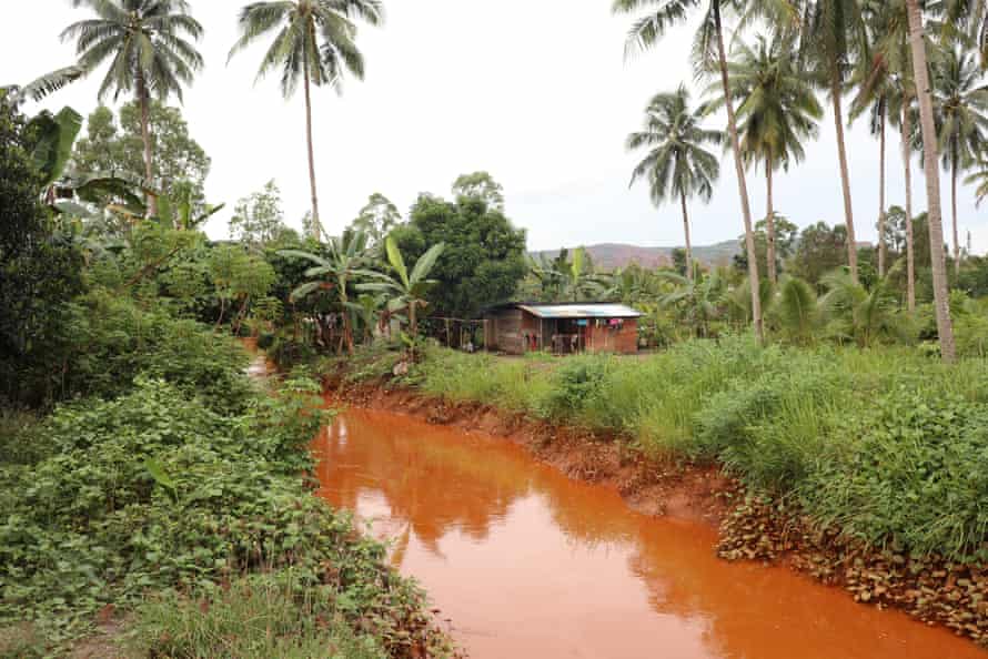 Canals made by the company drain away water and mud from mining activities. This canal runs through a residential area and into the sea.