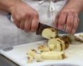a man chopping a potato