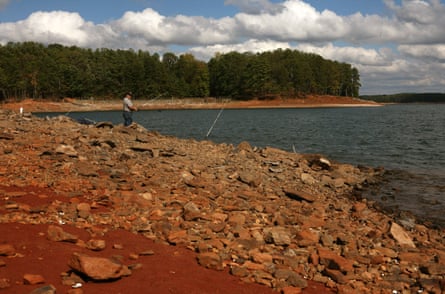 A man fishes on an exposed bank