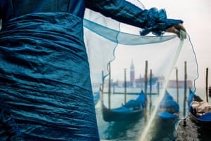 Dressed in costume, a tourist takes in the views of the canals and gondolas in Venice.