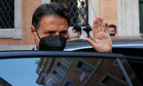 Giuseppe Conte, wearing a face mask, waves from behind the door of a car