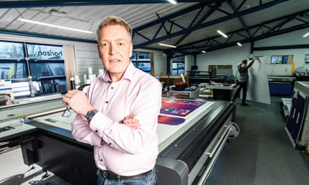 Andrew Moss poses for a photograph in the printing shop of his marketing company