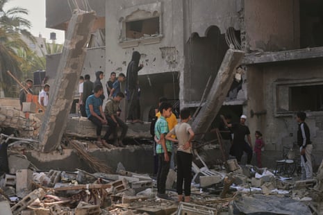Palestinians inspect a house destroyed by Israeli airstrikes in Deir al-Balah, 21 May.