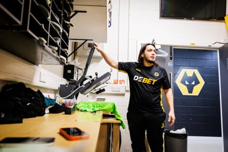 Sean Ruiz using a machine to print letters and numbers to shirts