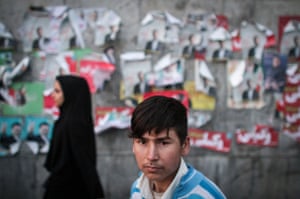 A boy stands in front of electoral posters in downtown Tehran.