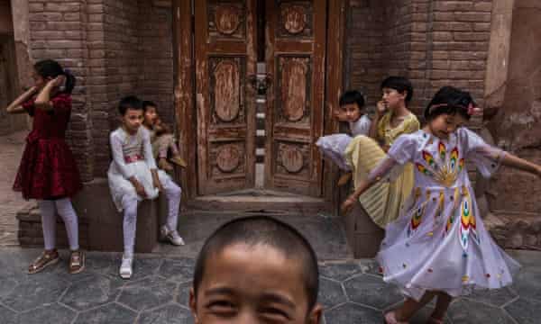 Uygur çocukları, Çin makamları tarafından kapatıldıktan sonra Haziran 2017'de Kaşgar'da bir caminin önünde oturuyor.