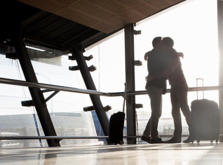 Two men embrace at an airport.