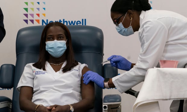Sandra Lindsay, left, is inoculated with the Covid-19 vaccine by Dr Michelle Chester, in the Queens borough of New York City