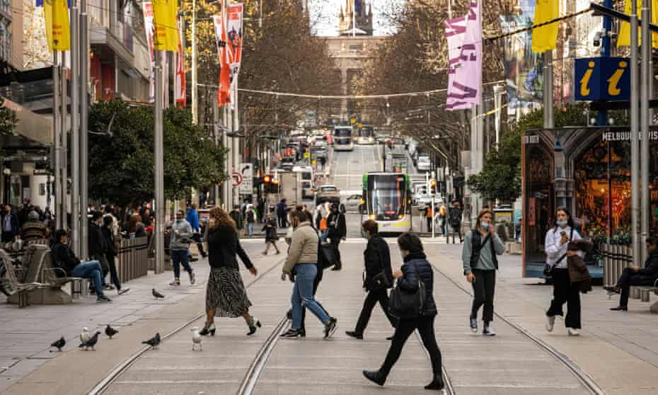 People are seen crossing Bourke Street Mall in Melbourne, Australia. 