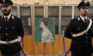 Italian police stand next to the masterpiece by Austrian artist Gustav Klimt.
