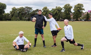 Ben Aitken surrounded by senior footballers stretching