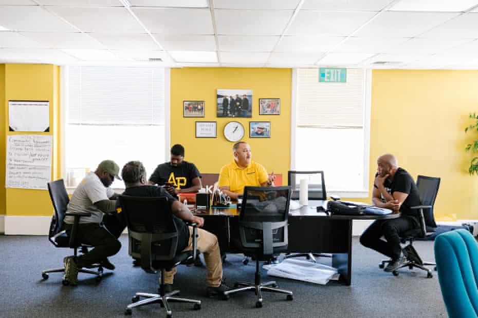 Julian Balderama, a neighborhood change associate, center, during a meeting at Advance Peace's Stockton office.
