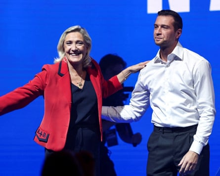 Marine Le Pen and Jordan Bardella embracing each other.