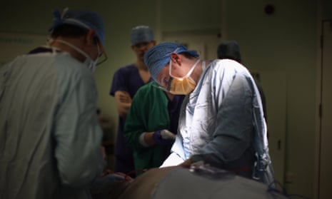 people in scrubs performing an operation at Queen’s Elizabeth Hospital, Birmingham