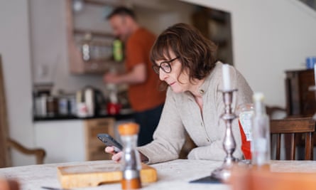 Zoe Williams at the dining table with husband in the background