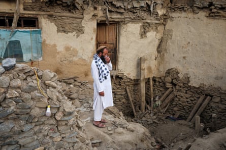 An Afghan man reacts as he stands amid the rubble of a collapsed house after a deadly magnitude-6 earthquake