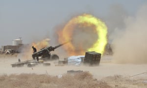 An Iraqi Shia fighter fires artillery during clashes with Isis near Falluja.