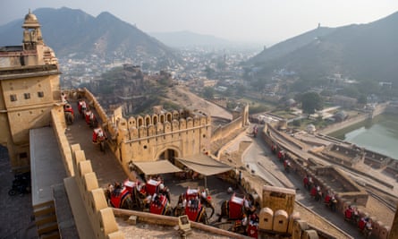 Elephants carry tourists up a stone passage to the Amber Fort.
