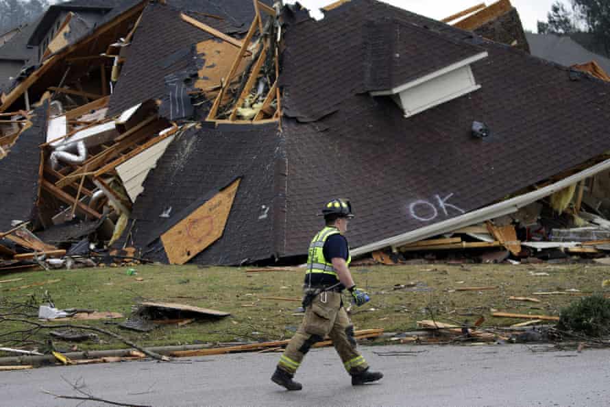 A firefighter surveys damage to a house in Eagle Point.
