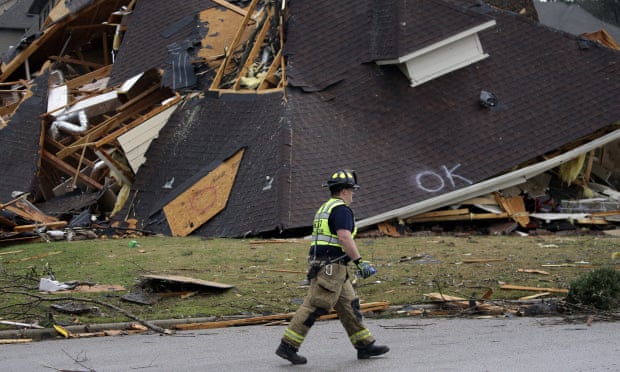 A firefighter surveyed damage to a house after a tornado touched down south of Birmingham, Alabama Thursday.