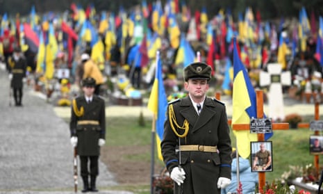 Servicemen of the Honour Guard stand next to the graves of Ukrainian soldiers at Lychakiv Cemetery in Lviv.