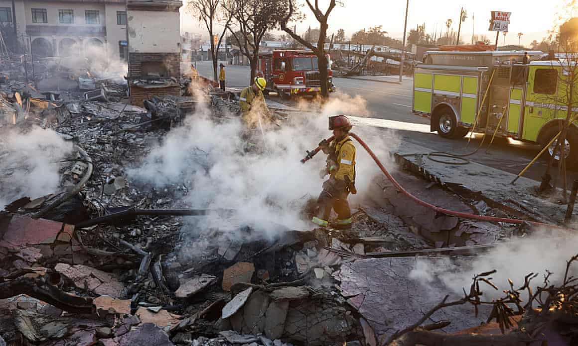 Firefighters hose down the burning remains of a structure in Altadena, California