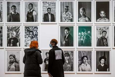 Tate visitors study portraits from the artist’s ongoing series Faces and Phases.