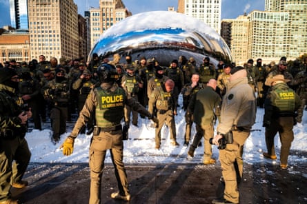US Border Patrol agents pose at the sculpture Cloud Gate, also known as the Bean, by Anish Kapoor.