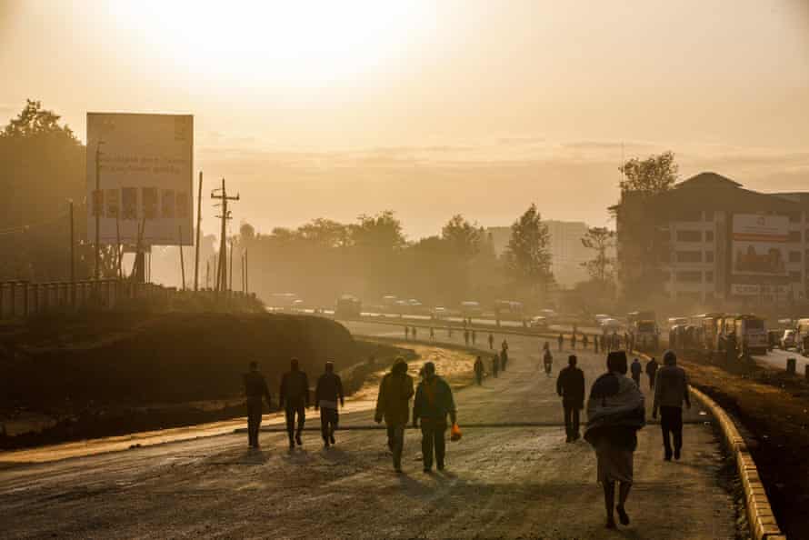 People walk to work along the construction site of the expressway in Nairobi