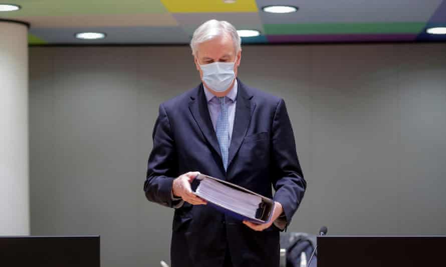 Michel Barnier holds the pages of the EU-UK trade deal at a Brussels meeting on Christmas Day.