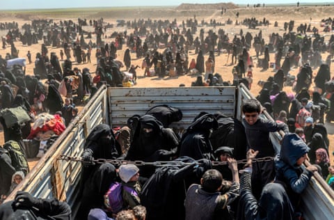 Women and children evacuated from Baghouz arrive at a screening area, in March last year