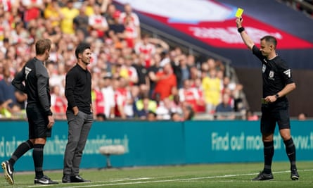 Stuart Attwell shows a yellow card to the Arsenal manager, Mikel Arteta