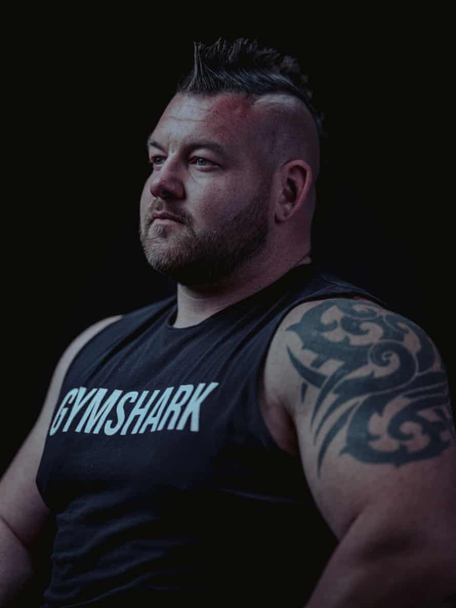 portrait of man with mohawk and tank top that says gymshark
