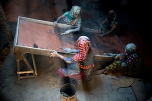 Women, in Bangladesh, working under a tin shade roof.
