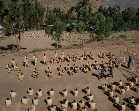 Young Amharas train for combat with some sparring and others sitting on the ground watching