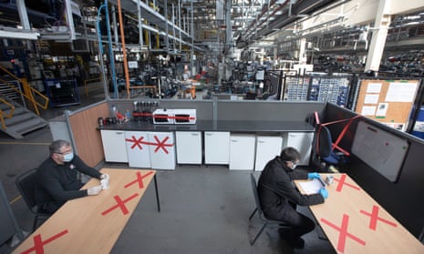 physically distanced workers sitting in a break area in  a Vauxhall car plant
