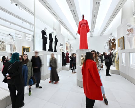 A large high-ceilinged hall with fashion pieces displayed on pedestals
