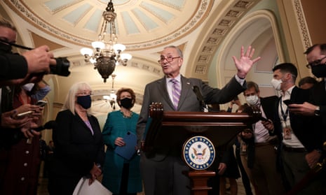 chuck schumer speaks to reporters while holding up hand