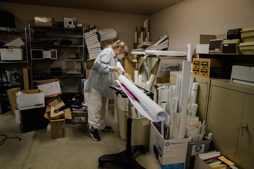 A woman looking over several posters and documents in a room