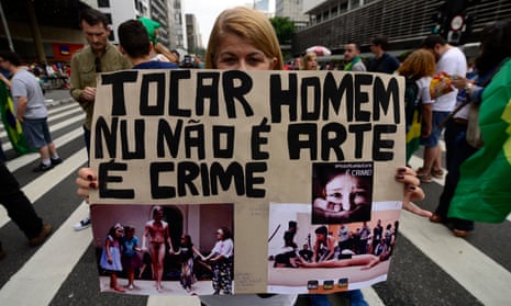 Protesters outside São Paulo’s Museum of Modern Art with placards showing Wagner Schwartz’s La Bête, in which a child touched the naked performance artist on the hand and foot. 