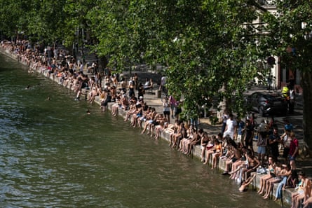 People sit on the banks of the Canal Saint-Martin