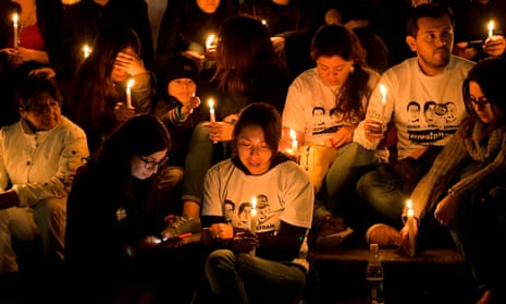 Friends and relatives of Ecuadorean murdered journalist Javier Ortega, photographer Paul Rivas and their driver Efrain Segarra, light candles and pray in Quito on 13 April 2018. 