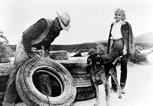 Clark Gable arregla una llanta de tractor mientras Monroe observa en The Misfits.
