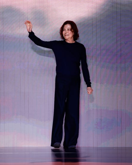 Silvana Armani, dressed all in black, smiles and waves from the catwalk