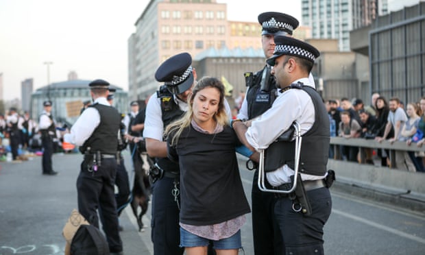 Police remove a Extinction Rebellion protester from Waterloo Bridge on Sunday evening.