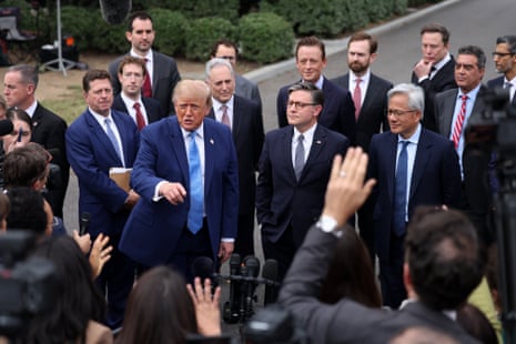 Trump gestures while speaking to reporters at the White House, surrounded by tech executives