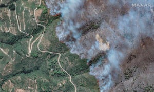 A line of smoke burns across the mountainside. To the left there are trees and grass; to the right there almost everything is burnt out.